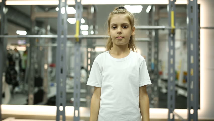 Little girl looks at her muscles | Shutterstock HD Video #1013736917