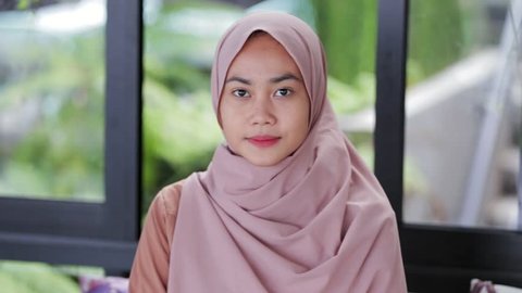 Portrait of beautiful southeast asian muslim woman with hijab smiling on camera edited and raw