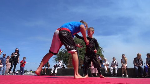 Kherson, Ukraine - 26th of May 2018: 4K Katran fighting club performs at the KhersOn Festival - Small boy learns flying throw from Master of Jiu-jitsu 
