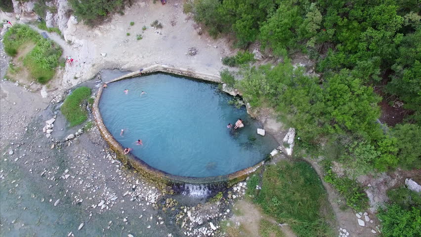 People swimming in a natural pool in Albania