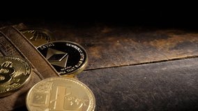 Popular crypto currencies with leather wallet on wooden board, Establishing panning shot.
