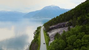 Road trip in beautiful norwegian fjord, drone aerial footage following the vehicle driving, travel in Norway, Scandinavia. 4K video