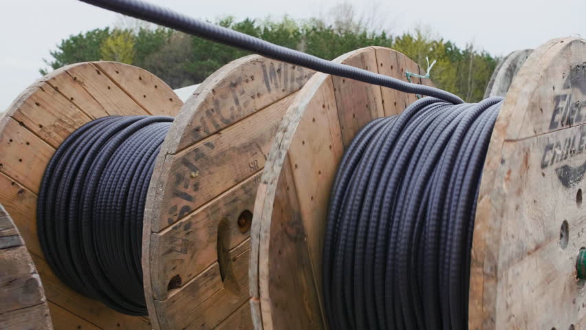 Thick gauge electrical wire being rolled out and prepared for installation.