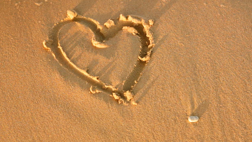 sea wave erases drawing hearts with sand