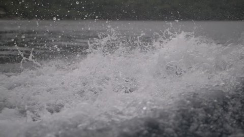 Slowmotion of splashing water created from boat
