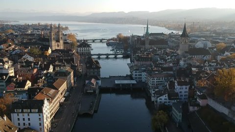 Aerial drone shot flying over the river Limmat in Zurich at sunset with lake Zurich in the background