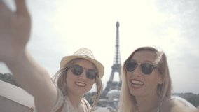 Two young females travelling in Europe taking selfie y the Eiffel Tower in Paris, France. People travelling in Europe taking selfies, Two young attractive women 