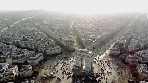 Parisian traffic around the along the Champs Elysees and the Arc de Triomphe in a long and smooth aerial shot.
