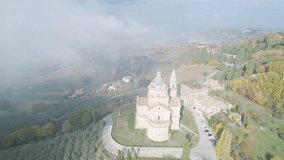 Approach from behind the clouds to the temple of San Biagio di Montepulciano in Tuscany. Video made with drone.