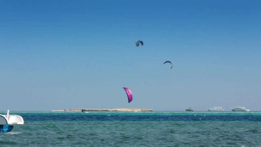 kite surfing - surfers on blue sea surface