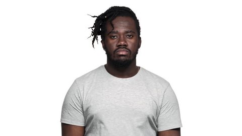 Portrait of helpless african american man with afro pigtails throwing hands aside and shrugging don't know or can't help slow motion, isolated over white background. Concept of emotions