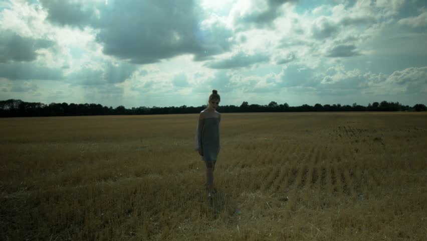 Beautiful girl is standing on a crooked field