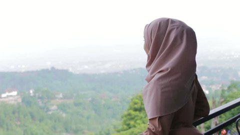 Happy pretty muslim woman smile with hijab looking at scenery edited and raw