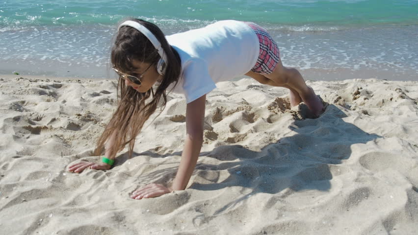 Fitness on the beach. The girl is doing sports on the beach.