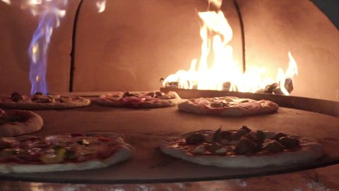 Pizzas Rotating in a Modern Fired Brick Oven