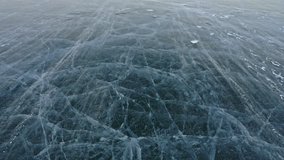 Snow is flying over surface of ice. Snowflakes fly on ice of Lake Baikal. Ice is very beautiful with unusual unique cracks. Snow sparkles and glows in red. Shooting slow motion 60fps. Picture at - Powered by Shutterstock - Get 15% off with code: PIKWIZARD15