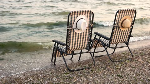 Checkered deck chairs on the sandy beach. Romantic summer vacation on seashore.