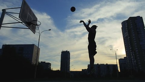 Man Basketball Player Training Playing Basketball Field. Basketball Player Bouncing the Ball. Slow motion shot of basketball player training. 