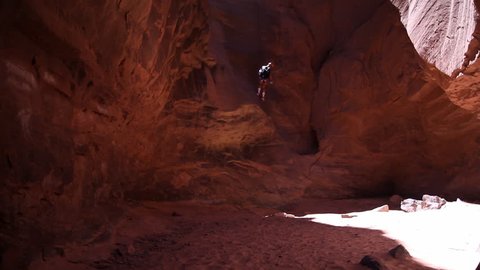 Man Repelling down into an Arid Red Canyon 스톡 비디오
