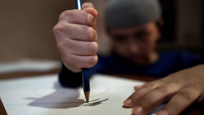 Frustrated ADHD afflicted young religious boy scribbling angrily on paper with pencil in school then ripping up sheet and crumpling into a ball Royalty-Free Stock Footage #1013839739