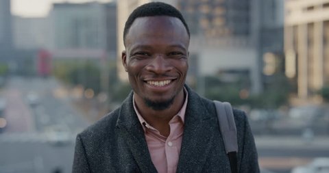 portrait happy african american businessman laughing enjoying successful lifestyle professional black entrepreneur in city at sunset slow motion real people series