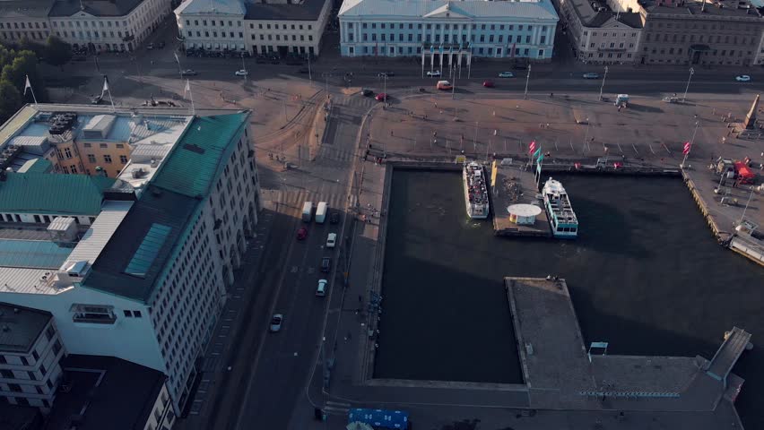 Aerial drone view of Helsinki capital city of Finland. Camera tilting up at Kauppatori, president castle and church during sunny summer day.