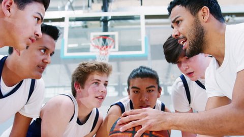 Male High School Basketball Players Joining Hands On Ball During Team Talk With Coach Stock-video