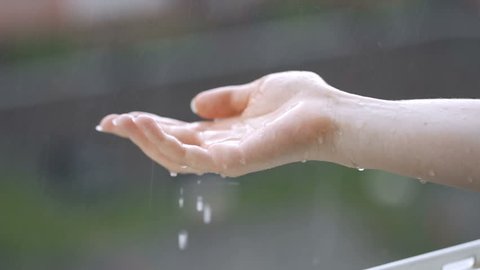 Female hands under falling clean water drops