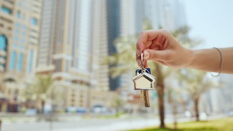 Hand girl holds the keys. The concept of buying an apartment or car in Dubai. Hand close-up.