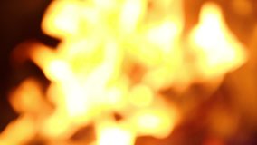 Closeup view of real bright burning fire in fireplace. Christmas (Xmas) or New Year shiny blurry bokeh video background
