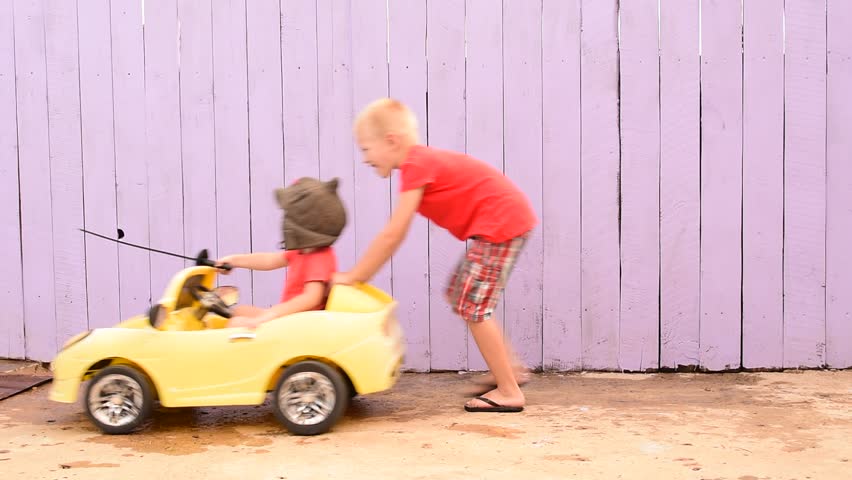 Funny child rolling his younger brother in yellow car with plastic sword. boy dreams of battles, victories and adventures. concept of moral education, patriotism, hero, super. Kids happy together
 Royalty-Free Stock Footage #1013883473