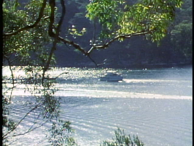 SYDNEY, AUSTRALIA, 1985, Lake, cove, cabin cruiser boat passing, backlighting