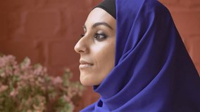 Young muslim woman in hijab with pierced nose looking at camera and smiling, portrait of beautiful happy lady
