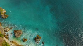Aerial view of turquoise tropical ocean and rocks in Bali.