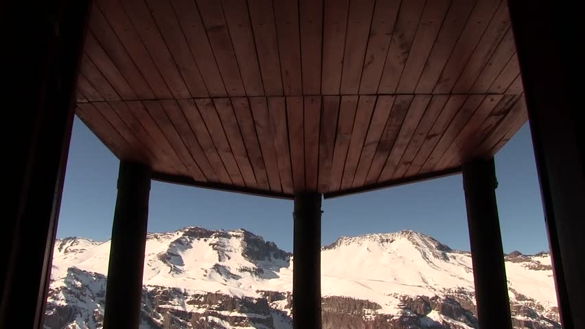 Tilt down of mountain range from the balcony of a room