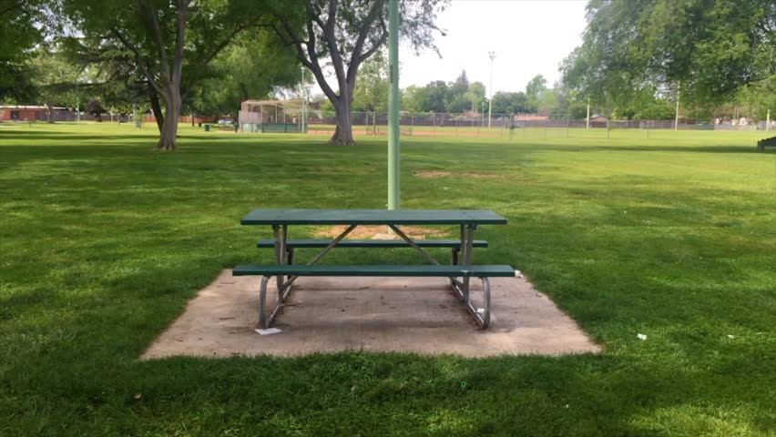 Time-lapse of spinning around a picnic table in an empty park