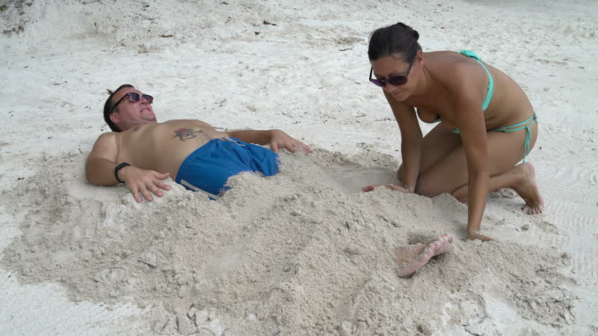A woman falls asleep to a man with sand.