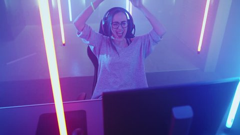 High Angle Shot of the Beautiful Friendly Pro Gamer Girl Playing in Online Video Game and Streaming it. She Wins Tournament and Celebrates.  Shot on RED EPIC-W 8K Helium Cinema Camera.