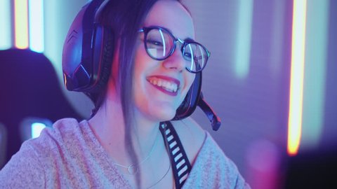 Beautiful Friendly Pro Gamer Girl Does Video Game Gameplaystream, Wearing Headset Talks / Chats with Her Fans and Team into Headphones Microphone. Shot on RED EPIC-W 8K Helium Cinema Camera.