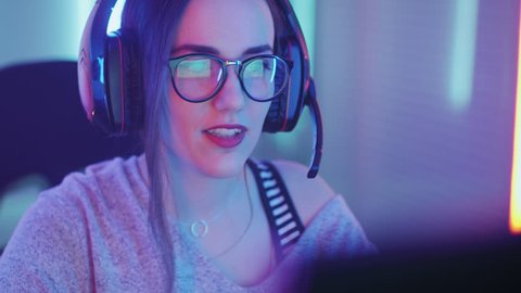 Beautiful Friendly Pro Gamer Girl Does Video Game Gameplaystream, Wearing Headset Talks / Chats' with Her Fans and Team into Headphones Microphone. Shot on RED EPIC-W 8K Helium Cinema Camera.