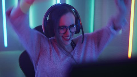 Beautiful Friendly Pro Gamer Girl Does Video Game Gameplaystream, Wearing Headset Talks / Chats' with Her Fans and Team into Headphones Microphone. Shot on RED EPIC-W 8K Helium Cinema Camera.