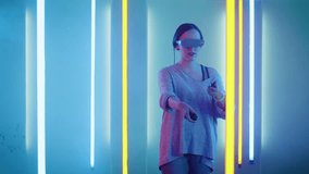 Beautiful Young Girl Wearing Virtual Reality Headset Draws Abstract Lines and Figures with Joysticks  Controllers. Creative Young Girl Does Concept Art with Augmented Reality.  Shot on RED EPIC-W 8K 