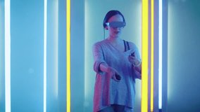 Beautiful Young Girl Wearing Virtual Reality Headset Draws Abstract Lines and Figures with Joysticks  Controllers. Creative Young Girl Does Concept Art with Augmented Reality. Shot on RED EPIC-W 8K 