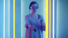 Beautiful Young Girl Wearing Virtual Reality Headset Draws Abstract Lines and Figures with Joysticks  Controllers. Creative Young Girl Does Concept Art with Augmented Reality. Shot on RED EPIC-W 8K.