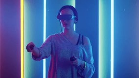Beautiful Young Girl Wearing Virtual Reality Headset Draws Abstract Lines and Figures with Joysticks  Controllers. Creative Young Girl Does Concept Art with Augmented Reality. Shot on 4K UHD.