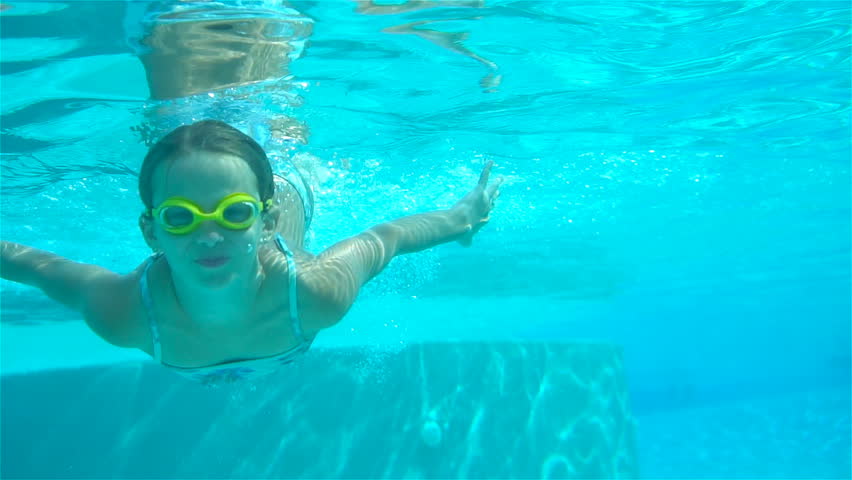 Happy little girl swimming underwater and smiling looking at camera | Shutterstock HD Video #1013906024