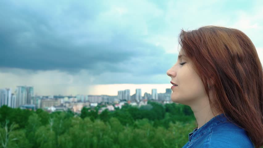 happy woman dreaming while standing on top of the mountain. young woman breathes fresh mountain air. woman portrait, relaxation concept. Young woman on the background of a distant big city. Fusion Royalty-Free Stock Footage #1013916983
