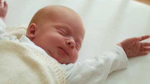 Newborn baby sleeping and waking up and opening eyes. Close-up. Sleeping Infant
