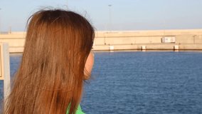 Lovely beautiful little girl standing over sea port in Valencia, Spain
