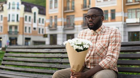 Pretty young lady meeting boyfriend on first date, man presenting white flowers